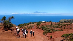 Abrante Grupo de senderismo caminando sobre las tierras rojas en Abrante y vistas del Teide